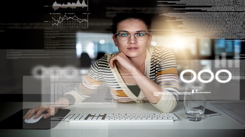 Woman sitting at computer with text floating around her.